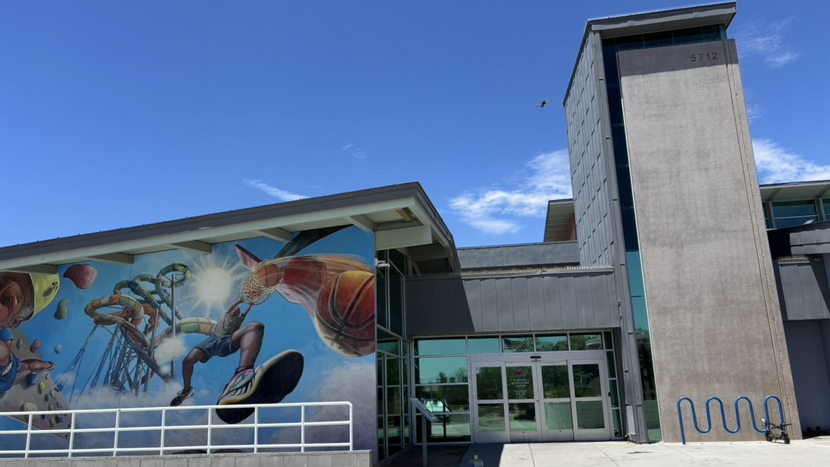 Whitney Recreation Center（5712 E. Missouri Ave.）。壁画のある建物が本館で、右奥の塔は屋外ウォーターパーク側（撮影：YO-MIDOKORO、2026年7月28日）
